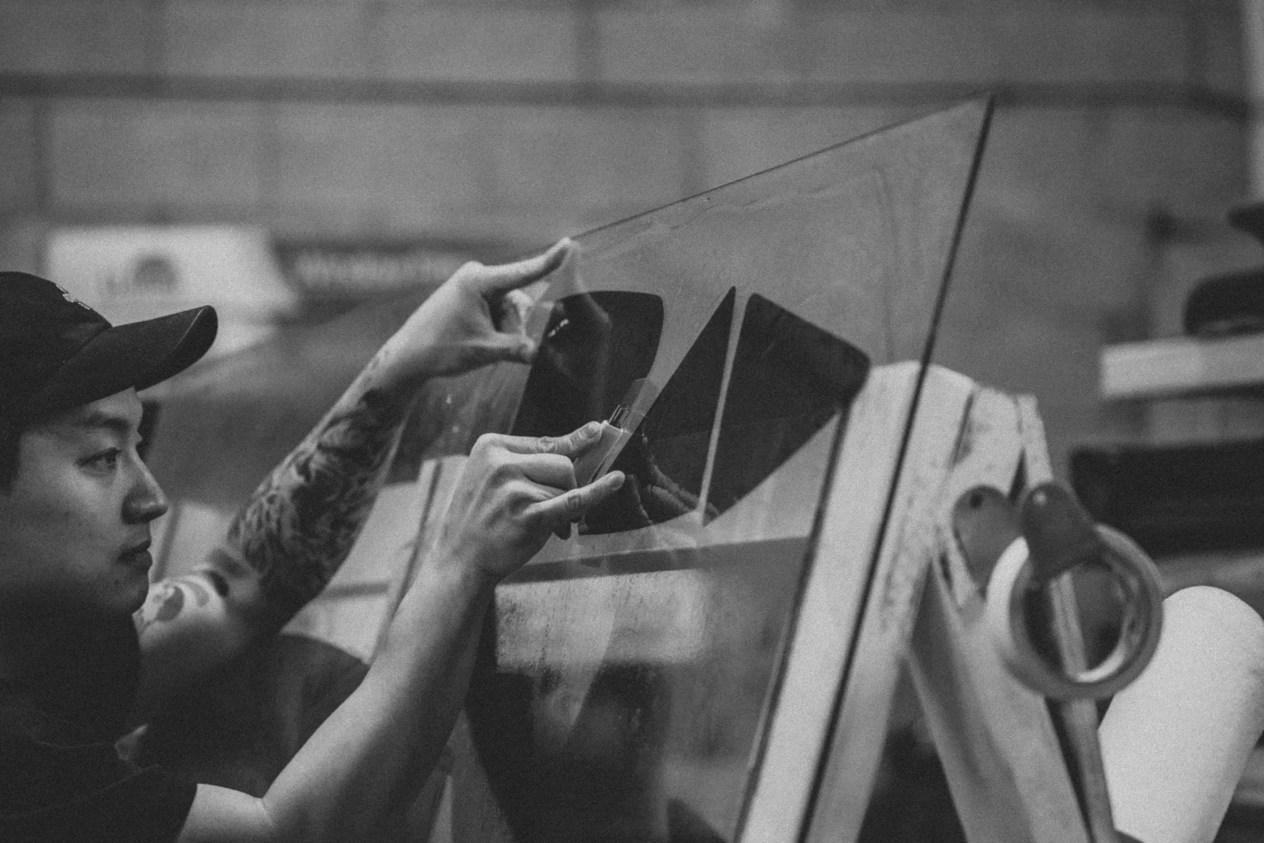 Technician holding a plotter-cut piece of LLumar film up to the light