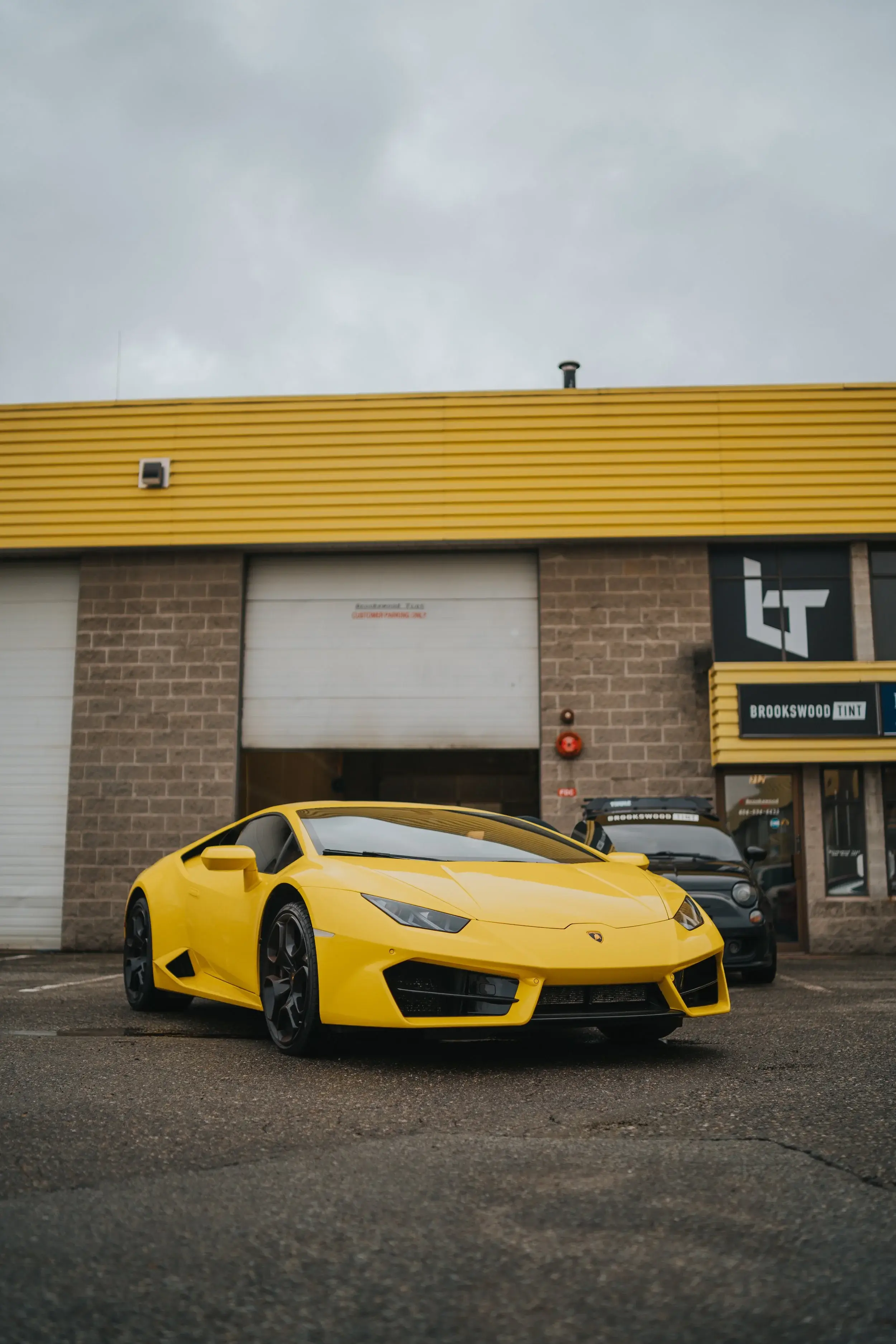Yellow Lamborghini Huracán parked outside the Brookswood Tint Shop storefront on Langley Bypass