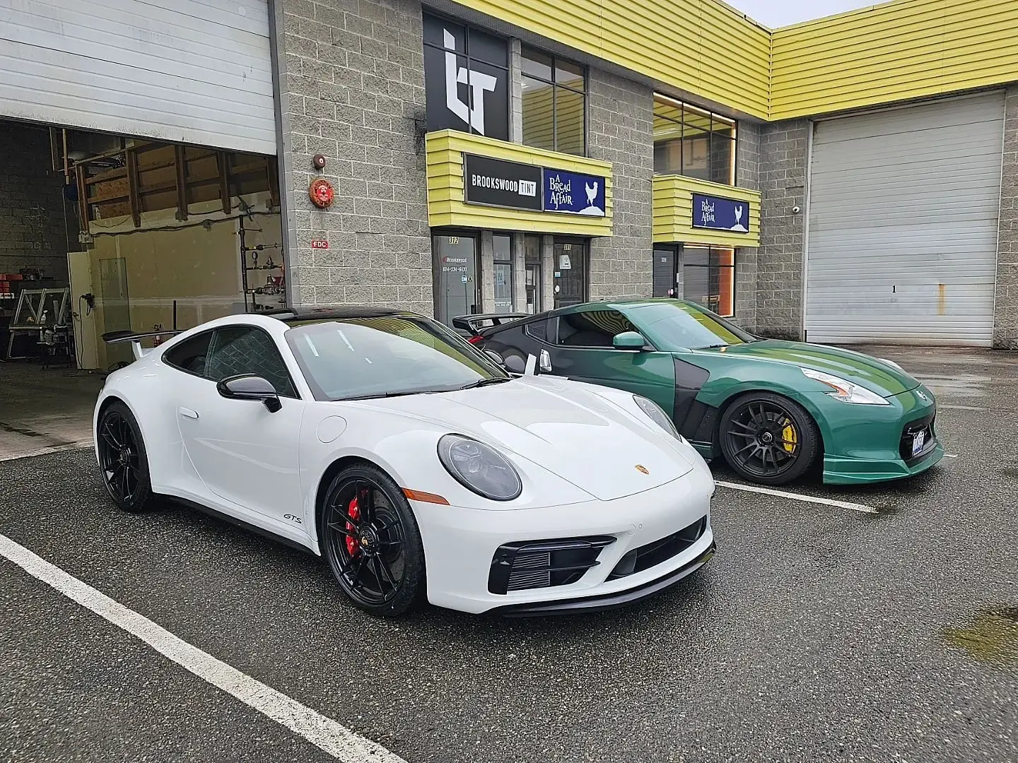 White Porsche 911 GTS with tinted windows outside the shop