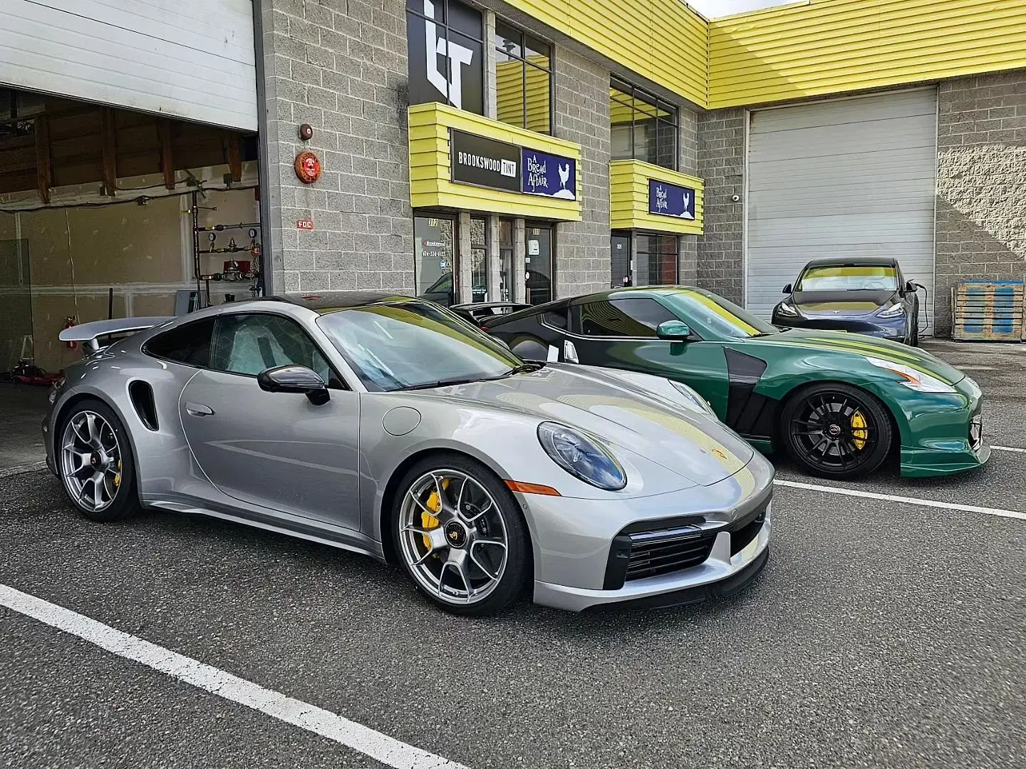 Silver Porsche 911 Turbo S parked outside the Brookswood Tint Shop storefront