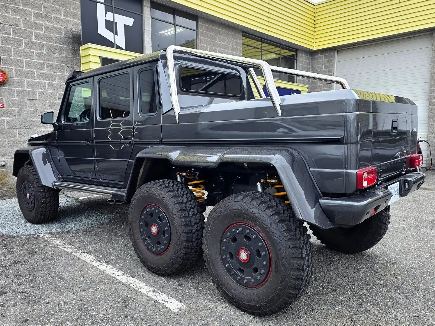 Rear three-quarter of a Mercedes G63 6x6 at the storefront