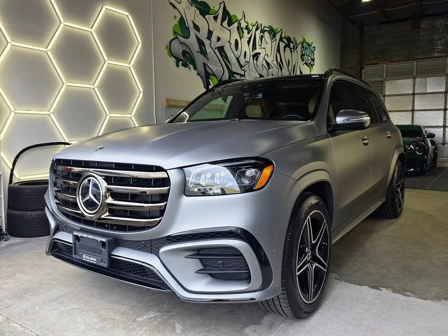 Matte gunmetal Mercedes GLS inside the shop under the hexagon lights