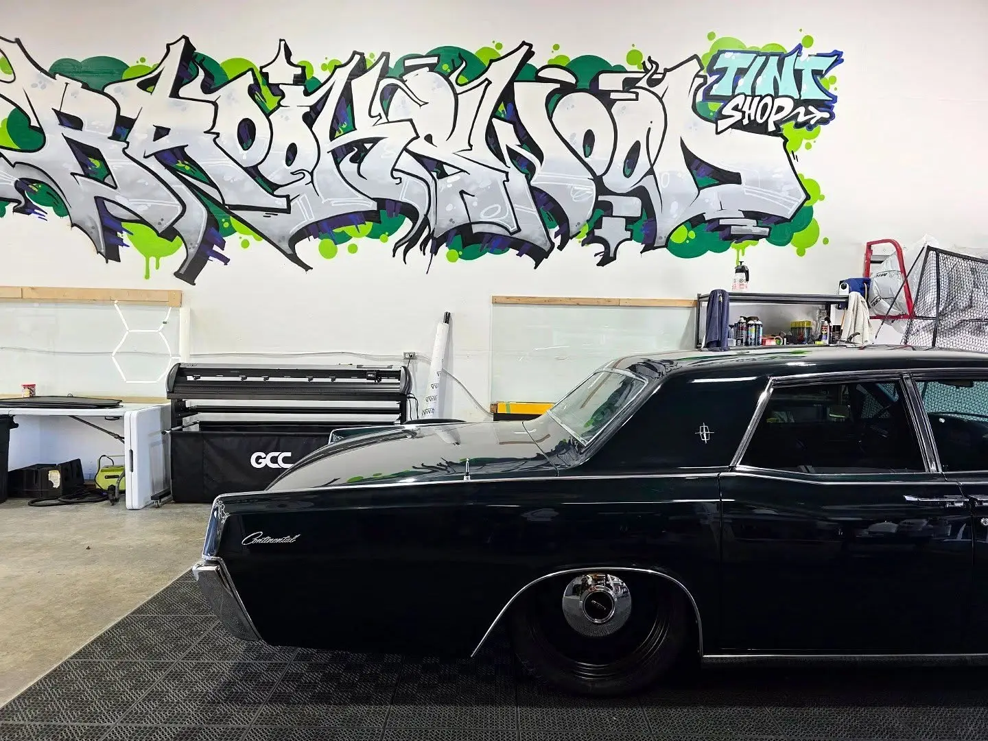 1967 Lincoln Continental inside the shop beside the plotter