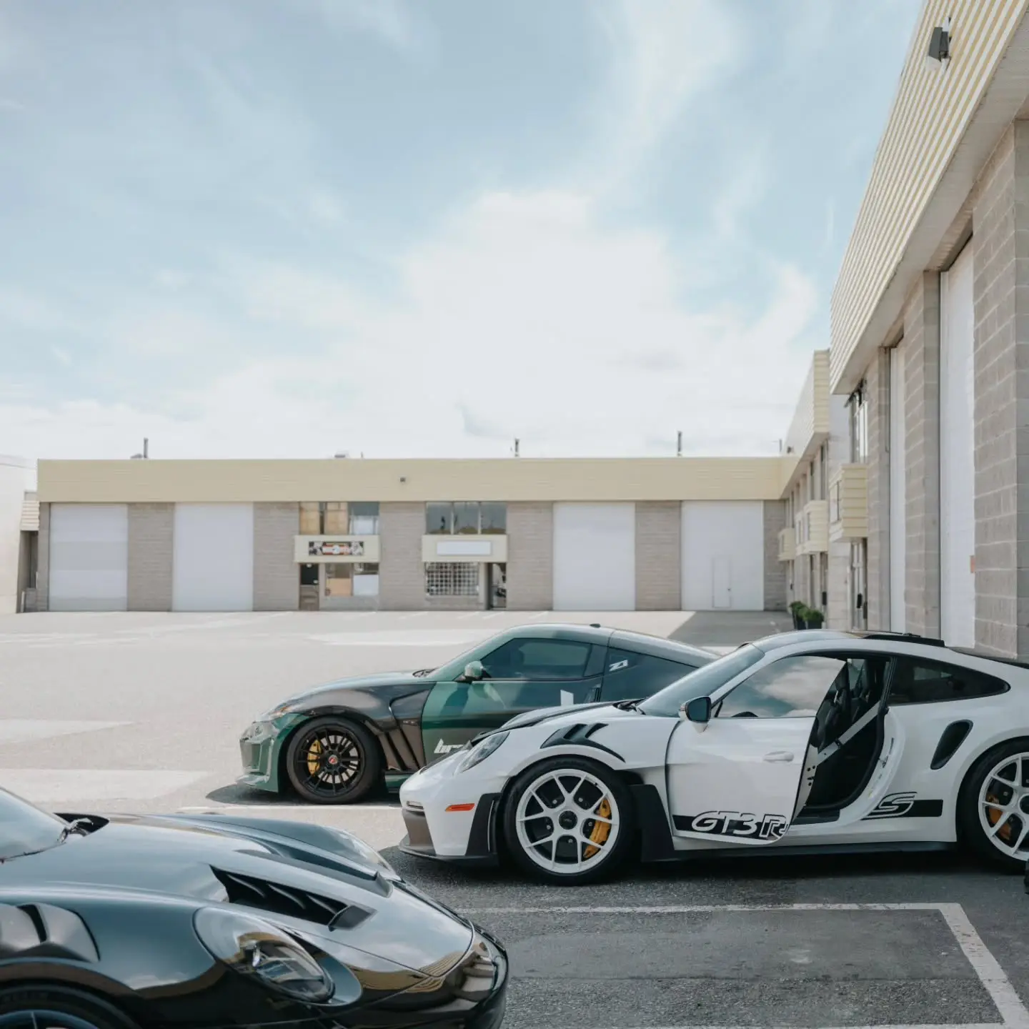 A Porsche 911 GT3 RS and a 911 Turbo S parked outside the shop