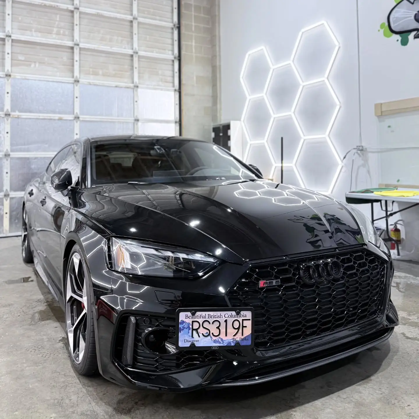 Black Audi RS5 under the hexagon lights inside the shop