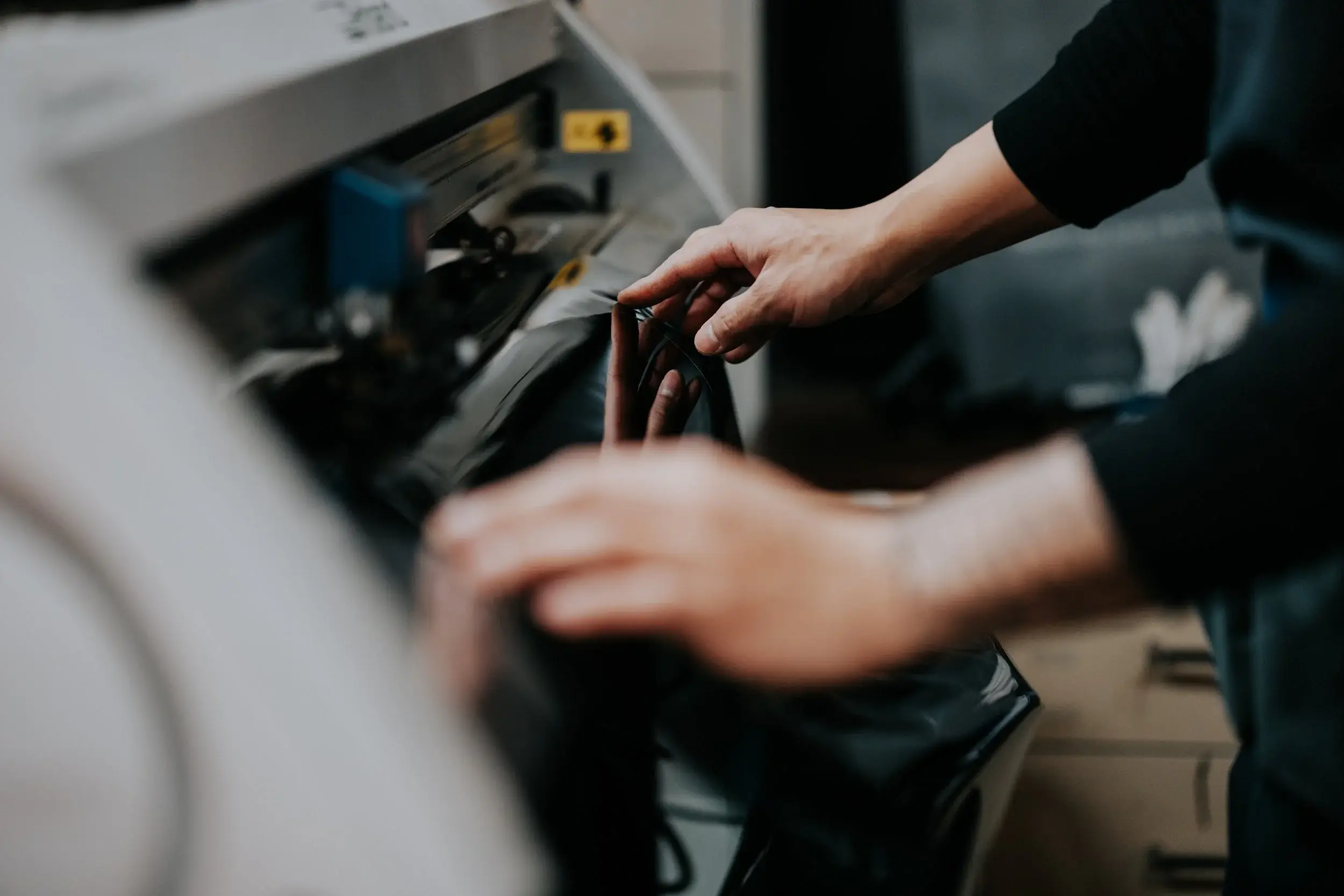 Hands guiding film through the plotter