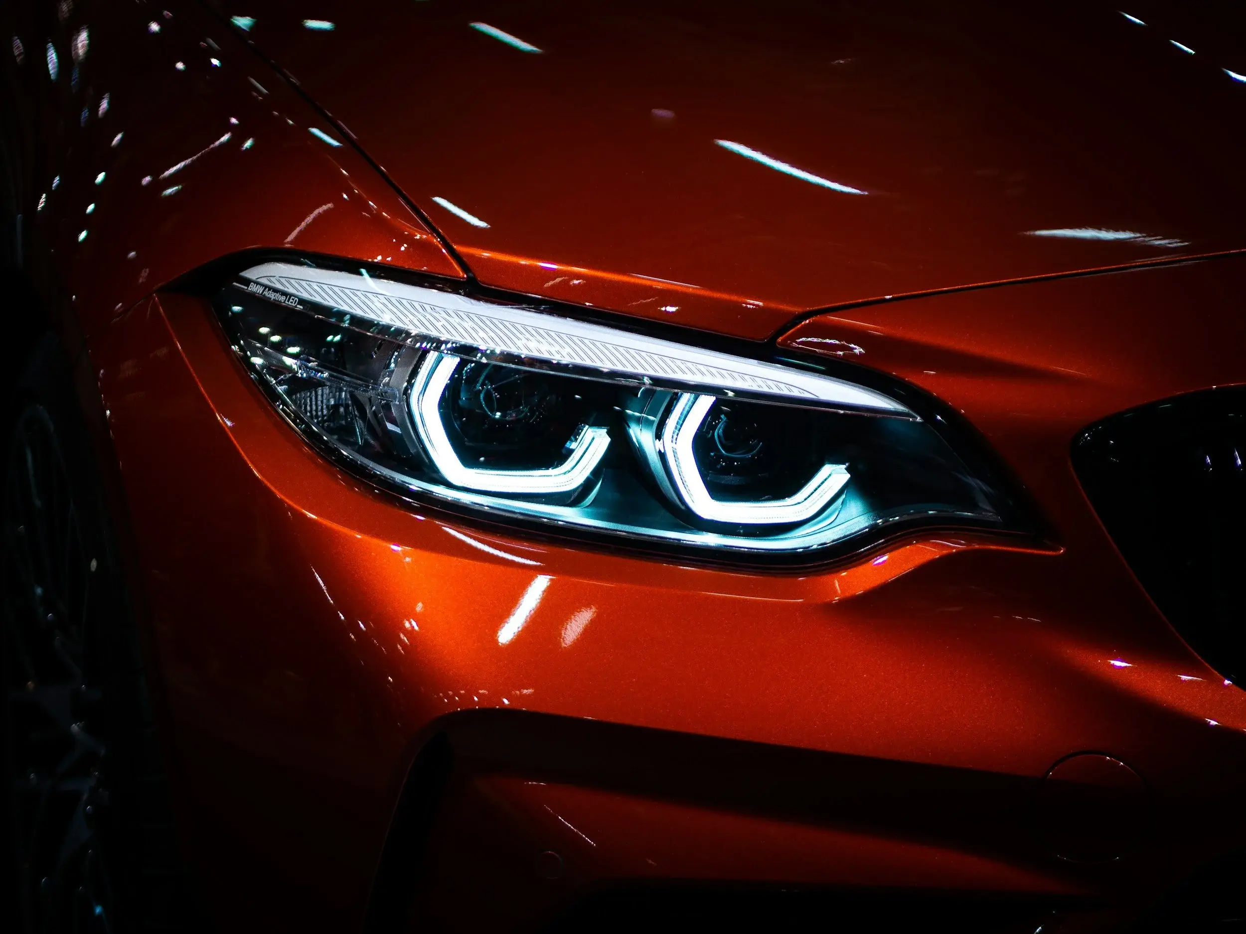 Close-up of a red BMW headlight with a smoked lens